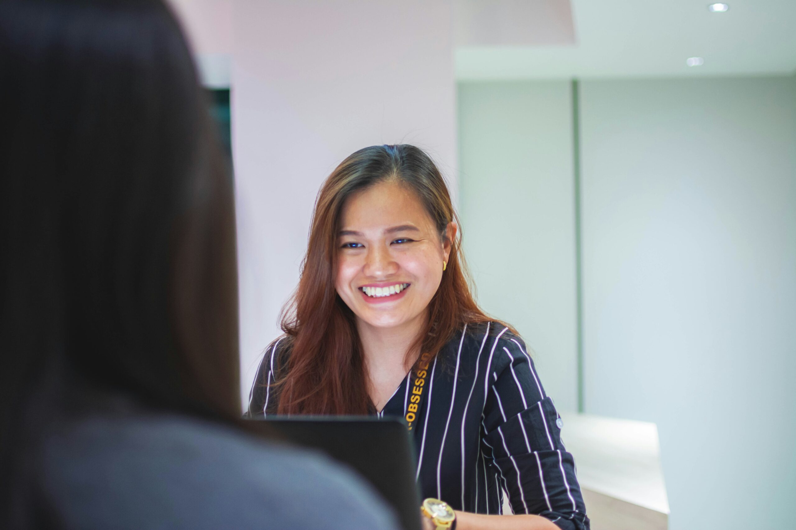 Smiling dental front desk receptionist ready to respond to patient inquiries