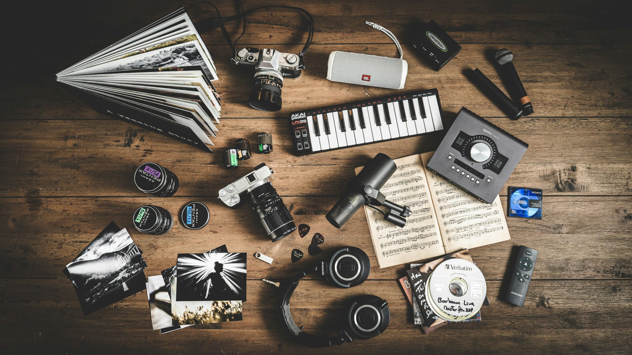 Creative content production tools and camera equipment on wooden table